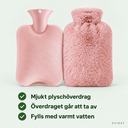 Rosa varmvattenflaska i ribbad PVC bredvid flaskan med mjukt plyschöverdrag, med texterna mjukt plyschöverdrag, överdraget går att ta av och fylls med varmt vatten