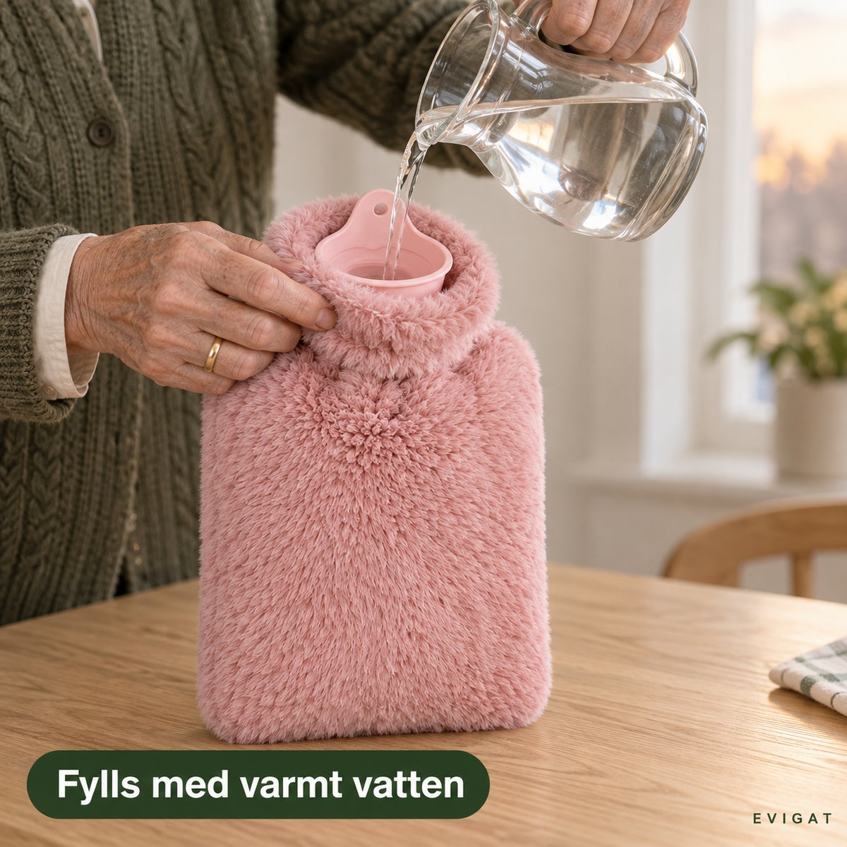 Händer häller klart vatten ur en glaskaraff i den rosa tratten på en varmvattenflaska med plyschöverdrag, med texten fylls med varmt vatten